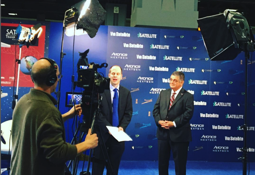Camera operator recording an on-stage interview at a trade show